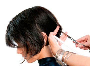 Perruquería Unisex Paquita - Estilista cortando el cabello a una mujer